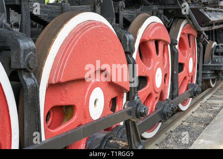 Red großen eisernen Räder eines alten Vintage Lokomotive auf die Bahn. Räder der Lokomotive. Die großen Räder. Stockfoto