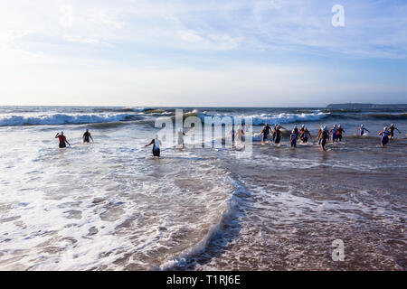 Triathlon nationalen Champs Durban, Südafrika - März 24, 2019: Athleten Frauen aus dem Strand in Ocean Wave surfen schwimmen Bein st Stockfoto