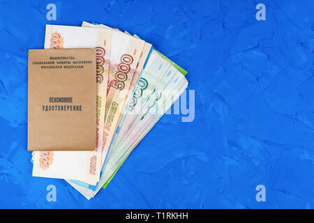 Pension Zertifikat der Russischen Bürger vor den Hintergrund der Banknoten und Münzen. Konzept der Rentenreform. Stockfoto