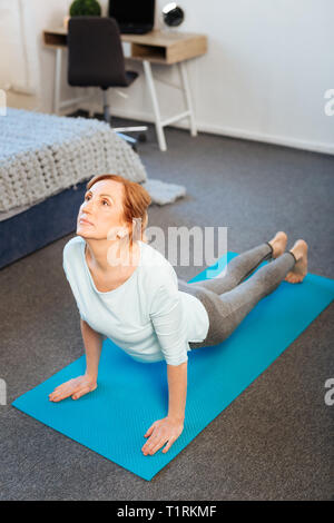 Fokussiertes Licht - angestellt Dame in verführerische Outfit tun Push-ups Stockfoto