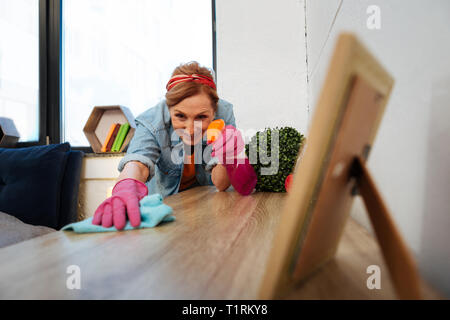 Konzentrierte Licht - behaarte reife Frau tragen rosa Gummihandschuhe Stockfoto