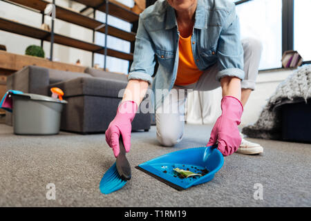 Hart arbeitenden Reiniger mit blauen Schaufel und Besen für das Sammeln von Schmutz Stockfoto