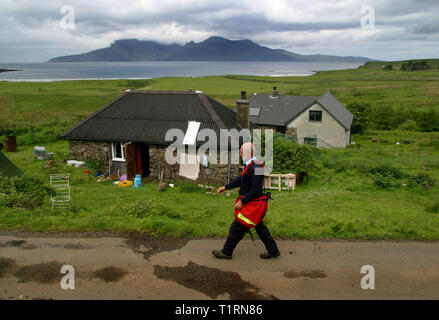 Postman John cormack liefert die Mail an laig Bucht auf der Hebriden Insel Eigg. Die Insel Eigg war eine Kette von Inseln, die Lüge der schottischen Westküste und wurde von einem staatlichen lifeline Service vom Festland aus erreichbar. Die Bewohner auf Eigg organisierte eine Buy-out der Insel in den späten 1990er und nahm es in gemeinschaftlichen Eigentums... Stockfoto