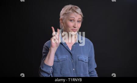 Closeup Portrait von Erwachsenen attraktive kaukasischen Frauen mit einem Sieg unterzeichnen und freundlich lächelnd, während bei Camera suchen Stockfoto