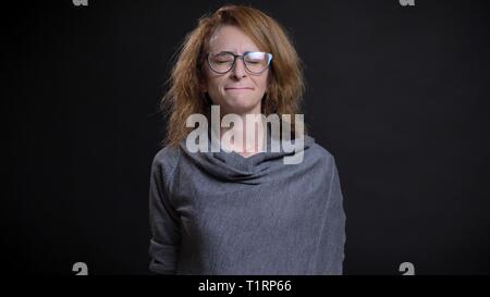 Closeup Portrait von mittlerem Alter extravagante rothaarige Frau in Gläser, deprimiert und traurig vor der Kamera Stockfoto
