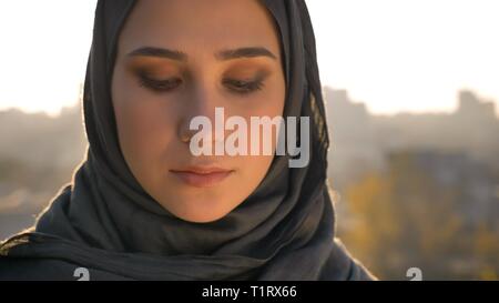 Closeup Portrait der jungen schönen arabischen Frauen in der Hijab, die mit der städtischen Einstellung auf dem Hintergrund Stockfoto