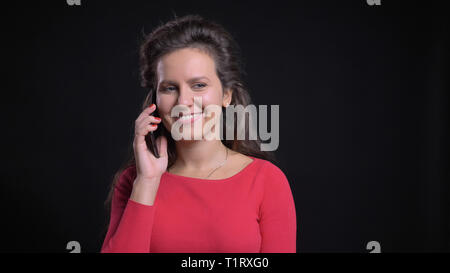Closeup Portrait von attraktiven mittleren Alters kaukasischen in einer ungezwungenen Gespräch am Telefon und lächelnd vor der Kamera Stockfoto