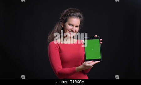 Closeup Portrait von attraktiven mittleren Alters kaukasischen Verwendung des Tablet und zeigt Grün chroma Bildschirm Kamera fröhlich lächelnd Stockfoto