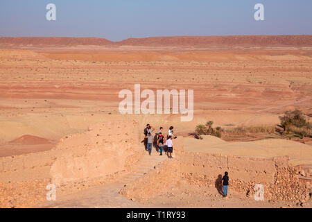 Touristen und einer der befestigten Mauern an Ksar Aït-Ben-Haddou in Richtung der offenen Wüste suchen, Aït Provinz Benhaddou‌, Ouarzazate, Marokko. Stockfoto