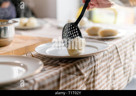Herstellung von cepelinai - Zeppeline ist nationale litauische Gericht. Frau Hand, warme Zeppeline auf einer Platte zu Hause Stockfoto