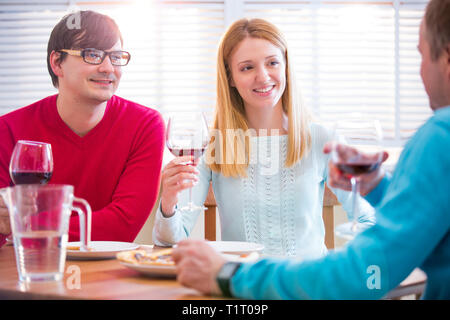 Eine Gruppe Junger Leute, Die Im Restaurant Essen und Wein trinken. Freunde speisen, feiern und Hängen aus. Hände toasten. Stockfoto