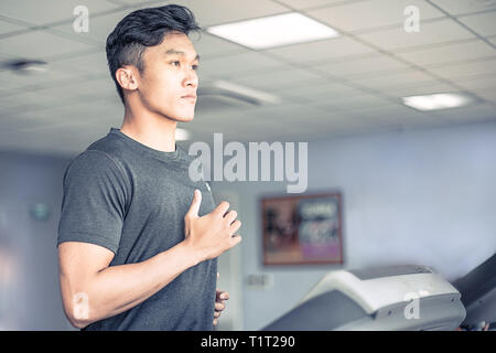 Asiatische junge Mann in Sportkleidung auf Laufband im Fitnessstudio | gesunde Aktivität Sport läuft Stockfoto