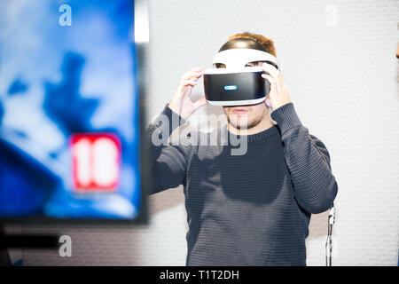 HELSINKI, Finnland - 4. NOVEMBER 2016: Neueste Virtual Reality Spiele von PlayStation 4. Junger Mann mit Vergnügen verwendet VR Head Mounted Displays. Stockfoto