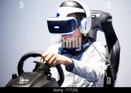 HELSINKI, Finnland - 4. NOVEMBER 2016: VR-Spiele. Teens verwenden virtuelle Realität Helme Sony PlayStation 4, Racing Simulator. Stockfoto