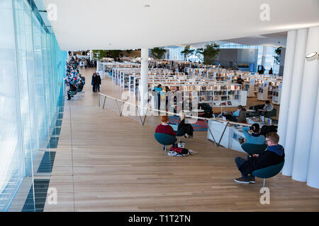 Neue Helsinki Central Library Oodi Interieur. Helle und geräumige moderne nördlichen Architektur. Bücherregale, Arbeitsbereich. Die Menschen lesen, arbeiten Stockfoto