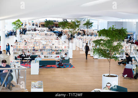 Neue Helsinki Central Library Oodi Interieur. Helle und geräumige moderne nördlichen Architektur. Bücherregale, Arbeitsbereich. Die Menschen lesen, arbeiten Stockfoto