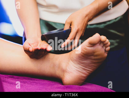 Fuß- und Beinmassage, Therapeut Öl gießen zu einem Fuß zu Massage Stockfoto