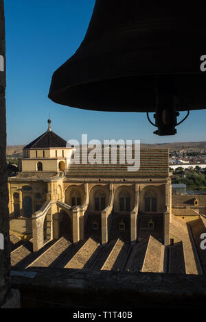 Der Blick vom Kirchturm in der historischen Mezquita über das Dach der Kathedrale von Córdoba, mit dem Profil einer Glocke im Vordergrund. Stockfoto