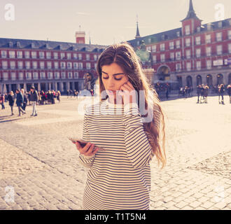 Verlorene junge touristische Frau Kontrolle smart Handy versuchen, Richtungen zu finden. Suchen besorgt und durchdachte Beratung das Handy app. In Touris Stockfoto