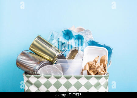 Sortieren von Müll für die Bearbeitung zu Hause - Korb auf einem blauen Hintergrund Stockfoto