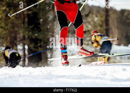 Füße Skifahrer Athlet Fahrten auf Schnee Spray von unter Skistöcke Stockfoto