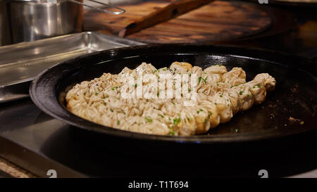 Große Pfanne mit Sheng jian Bao - Traditionelle Chinesische gebratene Knödel mit schweinehack Garnelen und Gemüse in Shanghai, China, kantonesische Küche Stockfoto