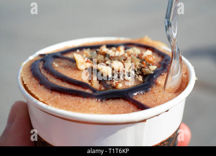 Türkisches Dessert irmik helvasi" "/Grießbrei mit Zimt Pulver und Erdnuss Stockfoto