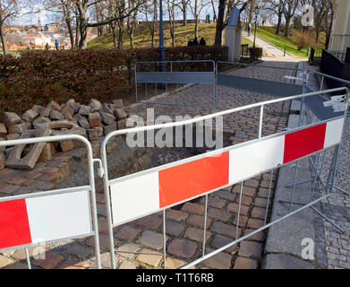 Dugged Gehweg und Loch im Bürgersteig. Der Schutz blockieren. Park mit Bäumen in der Stadt. Stockfoto