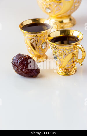 Stillleben mit traditionellen Goldenen arabischen Kaffee mit dallah und Schale. Weißer Hintergrund. Ramadan Konzept. Stockfoto