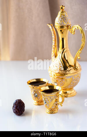 Stillleben mit traditionellen Goldenen arabischen Kaffee mit dallah und Schale. Weißer Hintergrund. Ramadan Konzept. Stockfoto