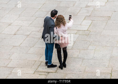 Ein paar Touristen nehmen eine selfie in der Plaza de San Jorge, Caceres, Spanien. Stockfoto