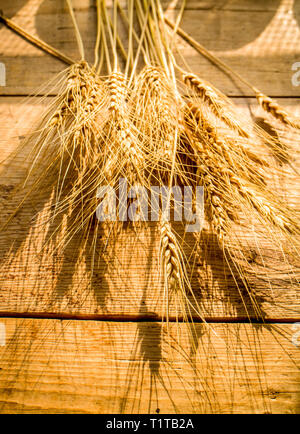 Die weizenähren auf einem Holztisch Stockfoto