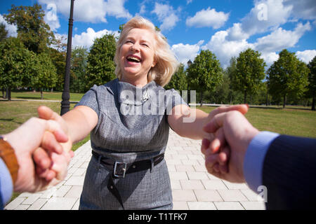 Folgen Sie mir. Porträt der schönen blonden Frau mittleren Alters im Sommer Park Stockfoto