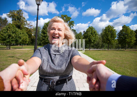 Folgen Sie mir. Porträt der schönen blonden Frau mittleren Alters im Sommer Park Stockfoto