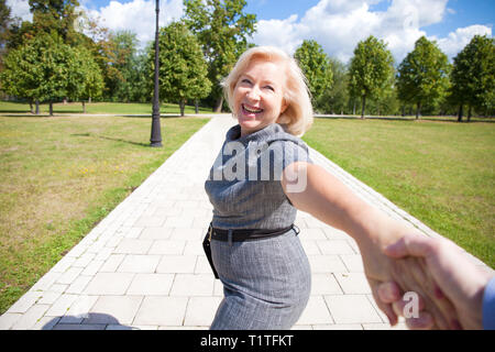 Folgen Sie mir. Porträt der schönen blonden Frau mittleren Alters im Sommer Park Stockfoto