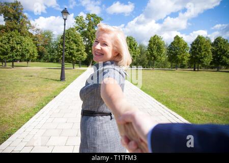 Folgen Sie mir. Porträt der schönen blonden Frau mittleren Alters im Sommer Park Stockfoto