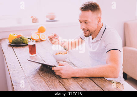 Freudige attraktiver Mann das Frühstück zu Hause in Stockfoto