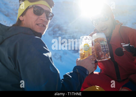 Freunden Bier trinken und jubelnd in den Bergen Stockfoto