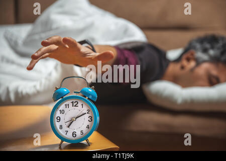 In der Nähe eines verschlafenen Kerl, der versucht, ein Vintage Uhr snooze Stockfoto