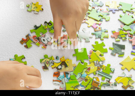 Händen eines Kindes spielen bunte Rätsel - Entwicklung eines Kindes durch spielen Spielzeug, das frühe Lernen. Stockfoto