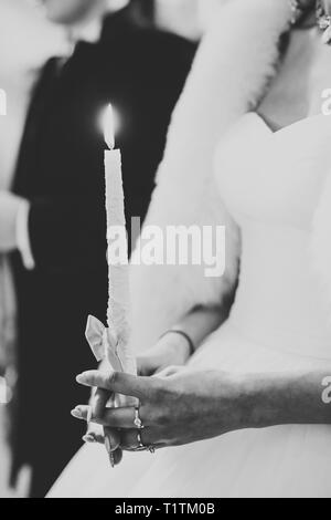 Braut und Bräutigam halten Kerzen in der Kirche. Stockfoto