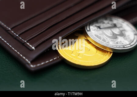 Physische Version von Silbernen und Goldenen bitcoins in der Nähe der Brieftasche. Stockfoto