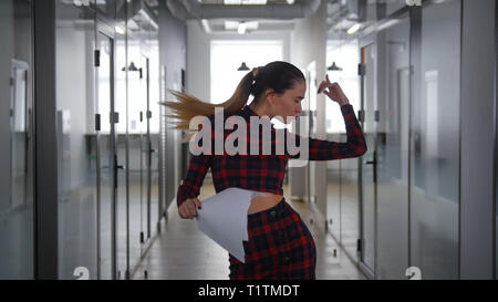 Eine aufgeregte Business woman dancing im Büro Flur Stockfoto