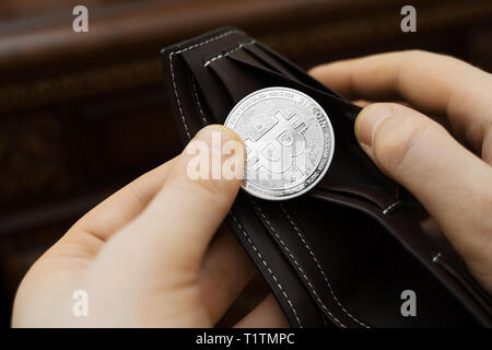 Mann hält physische Version von Silber bitcoin. Stockfoto