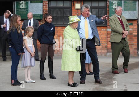 Königin Elizabeth II (links) mit Trainer Paul Nicholls auf der Manor Farm Stables im Ditcheat, Somerset, wo Sie mit Trainern und Mitarbeitern, um die Pferde auf der Parade und von der Universität von Bath über Forschungsprojekte auf den Pferdesport spinalen Verletzungen und Rennpferd wohl hören. Stockfoto