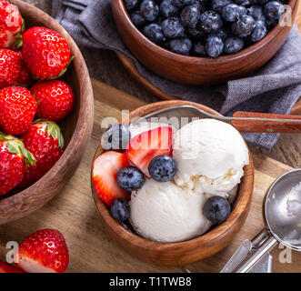 Ansicht von oben Vanilleeis mit frischen Blaubeeren und Erdbeeren in eine hölzerne Schüssel Stockfoto