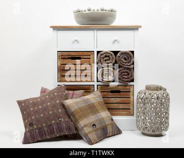 Kommode, Kissen, Plaids, Ornamente und Rattan Kerzenhalter auf weißem Hintergrund Stockfoto