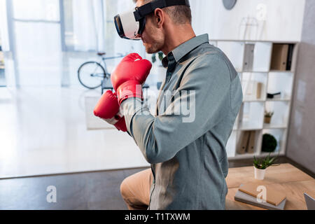 Zuversichtlich Geschäftsmann tragen virtual reality Headset und Boxhandschuhe im Büro Stockfoto