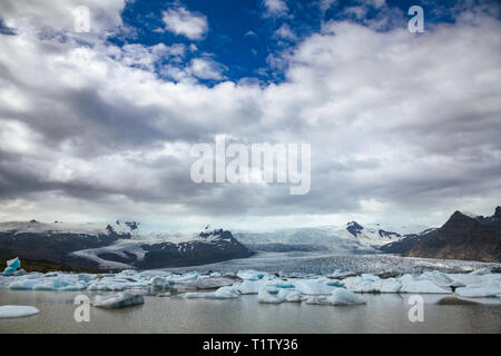 Schmelzende Eisberge in der Fjallsarlon Gletschersee mit Fjallsjokull Gletscher Kalben in Lagune, im Hintergrund Vatnajökull National Park, Stockfoto