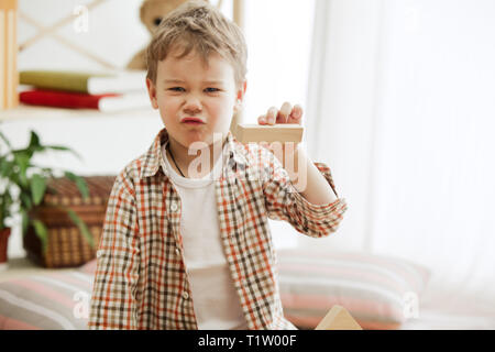 Kleines Kind auf dem Boden saß. Pretty Boy palying mit Holzwürfeln zu Hause. Konzeptionelle Bild mit Text oder negativen Raum und Mock-up für Ihren Text Stockfoto